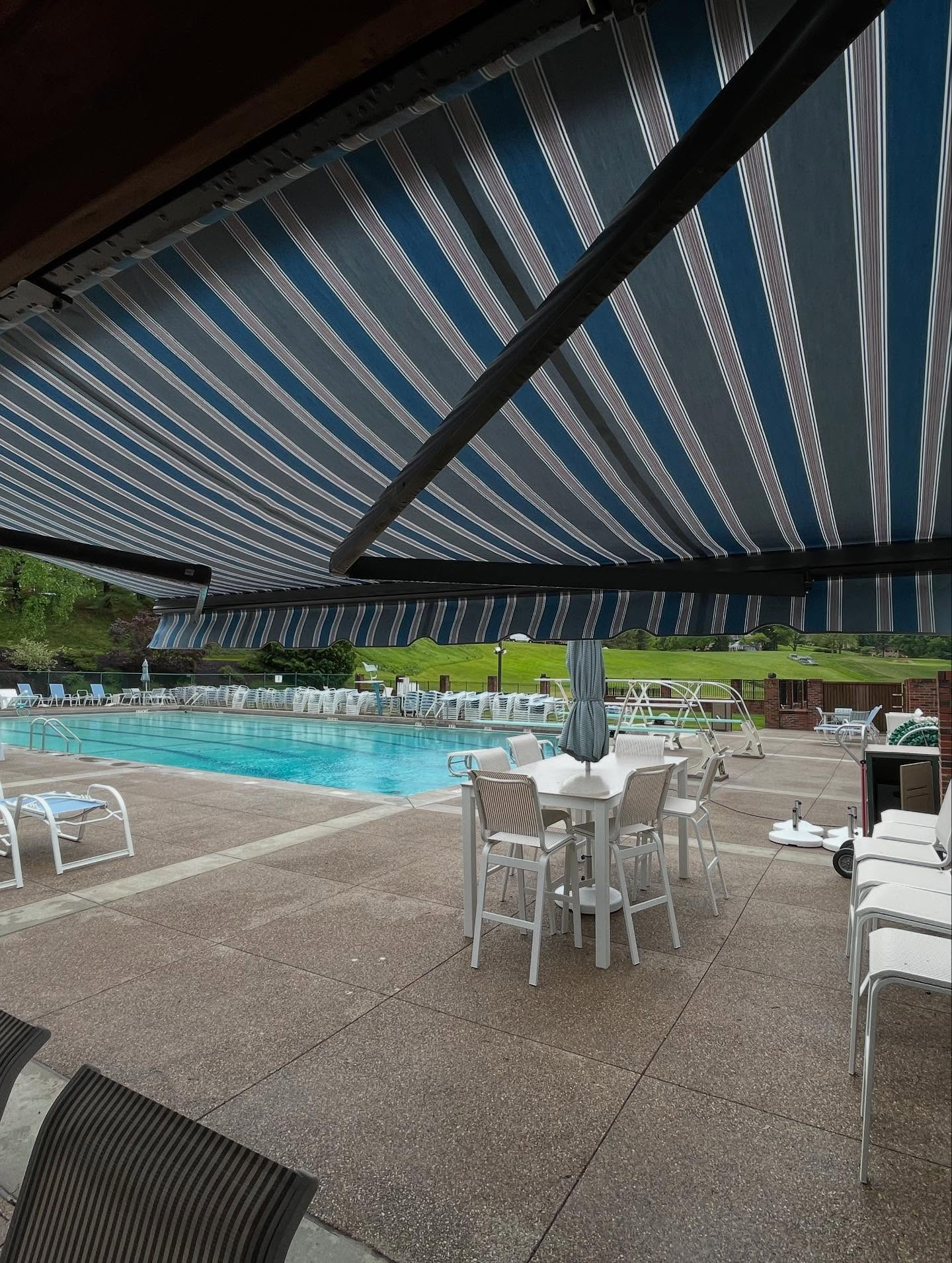 view of retractable awning near backyard inground pool