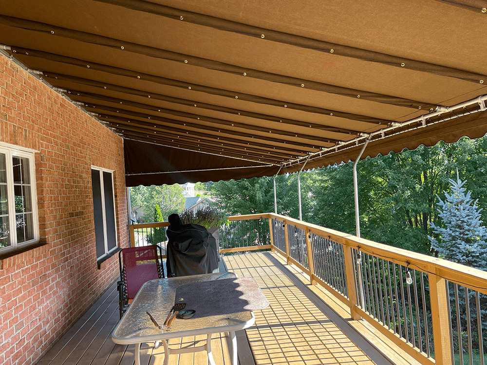 brown canvas awning installed over a deck
