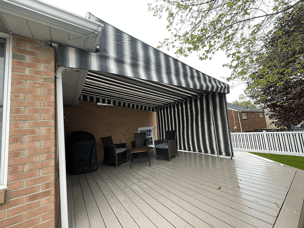 black and tan striped canvas awning installed over of a deck